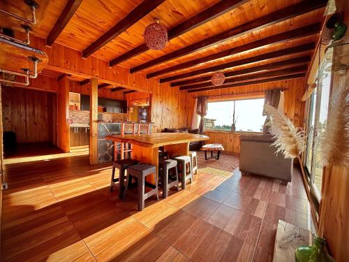 - une salle à manger avec une table et des chaises en bois dans l'établissement Cabaña en chovellen, à Pelluhue