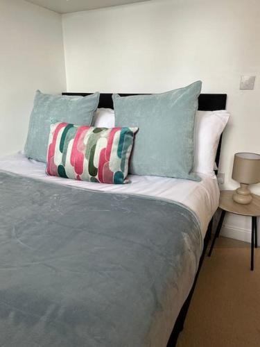 a bed with two pillows on it in a room at Lakeside apartment with FREE parking / M25 in Purfleet