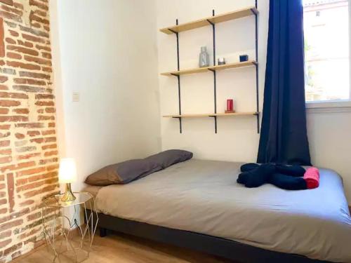 - une petite chambre dotée d'un lit avec des rideaux bleus dans l'établissement Capitole, Grand T1 bis, lumineux, neuf., à Toulouse