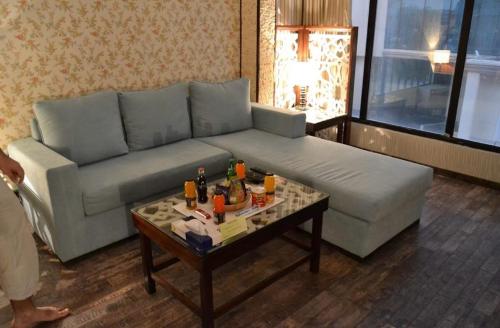 a living room with a couch and a coffee table at Cozy studio Minutes to Cornich & Bahrain bridge in Al Khobar