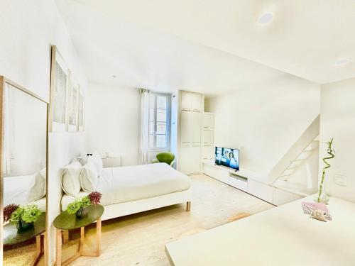 une chambre blanche avec un lit et une télévision dans l'établissement Èrsextius ABB Aix-en-Provence, à Aix-en-Provence