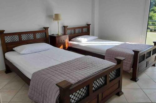 a room with two beds and a window at Icaria Great Filling House in Évdhilos