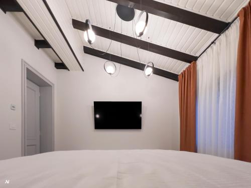 a room with a bed and a tv on a wall at First Apartments in Focşani