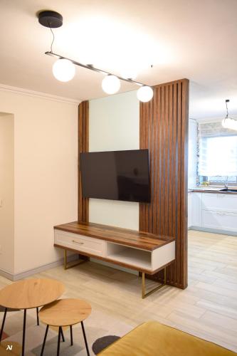 a living room with a flat screen tv on a wall at First Apartments in Focşani