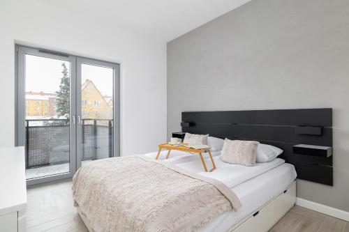 ein Schlafzimmer mit einem großen Bett und einem großen Fenster in der Unterkunft Złota Apartment with Balcony & Parking Near Zoo Katowice by Renters in Kattowitz