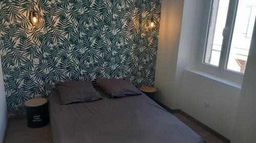 Cama en habitación con papel pintado en blanco y negro en Le Maricou 120m2 totalement rénové terrasse 40m2, en Châtillon-en-Diois