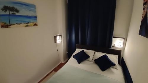 a bedroom with a bed with two blue pillows at Apartment Lea in Dubrovnik