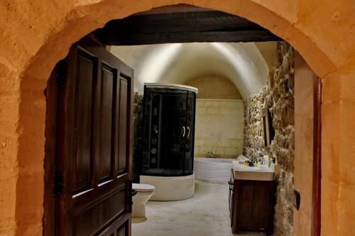 ein Badezimmer mit einer Badewanne, einem WC und einem Waschbecken in der Unterkunft HH Babil Konağı in Mardin