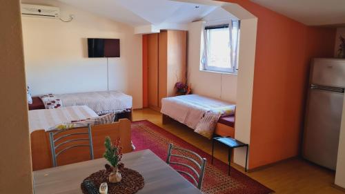 Habitación con 2 camas, mesa y cocina. en Apartments Magnolija, en Ohrid