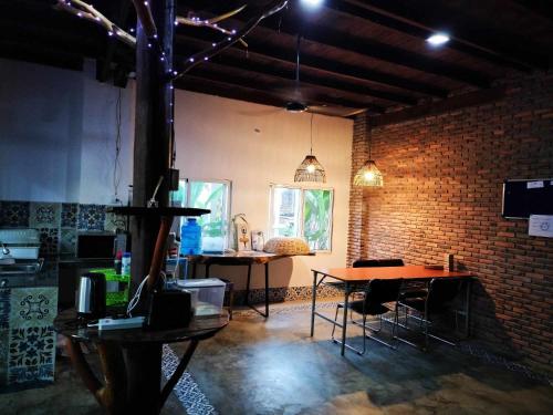 een kamer met een bakstenen muur en een tafel en stoelen bij Urban Farmhouse in Siem Reap