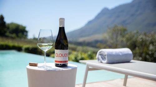 a bottle of wine sitting on a table with a glass at Clouds Estate in Stellenbosch