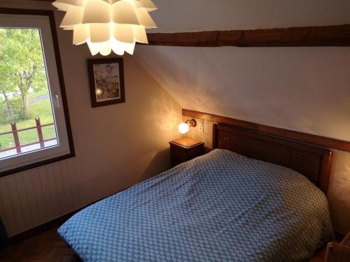 Henneveux的住宿－Le Gîte du Bois Groult，一间卧室设有蓝色的床和窗户。