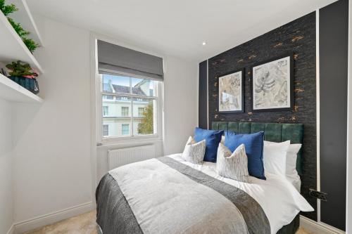 een slaapkamer met een groot bed met blauwe kussens bij Grand Flat in Little Venice - Sleeps 8 in Londen