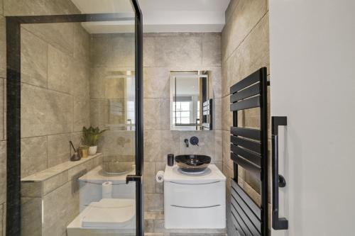 een badkamer met een douche, een toilet en een wastafel bij Grand Flat in Little Venice - Sleeps 8 in Londen