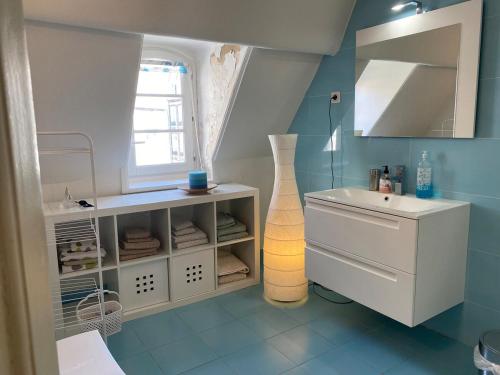 une petite salle de bain avec un lavabo et un miroir dans l'établissement La Notre Dame Conciergerie Leroy, à Boulogne-sur-Mer