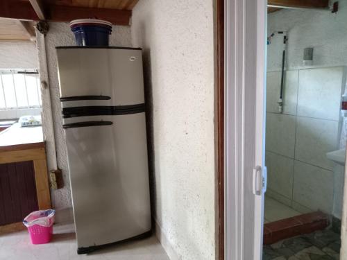 einen Kühlschrank in einer Küche neben einer Tür in der Unterkunft Casa España in Puerto Jiménez