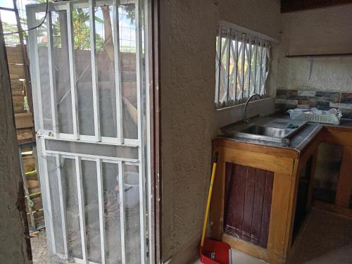 a room with a kitchen with a iron gate at Casa España in Puerto Jiménez