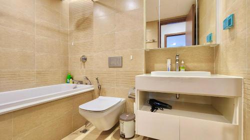 La salle de bains est pourvue de toilettes, d'un lavabo et d'une baignoire. dans l'établissement Vinhomes Metropolis Residence, à Hanoï