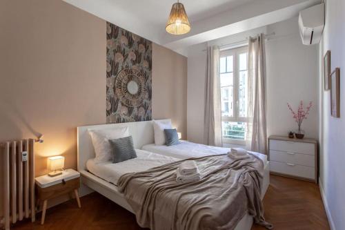 - une chambre avec un grand lit et une fenêtre dans l'établissement L1 Suite Auguste Valensin 10 min à pied Mer Clim&WIFI, à Nice