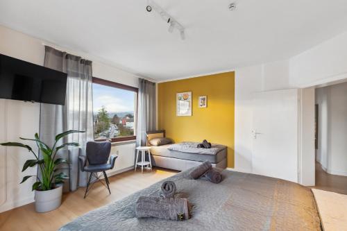 1 dormitorio con cama, sofá y TV en Amalfi Apartment A03 - 3 Zi.+ bequeme Boxspringbetten + smart TV, en Eltville am Rhein