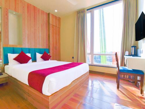 Hotel Anju Shree Inn في جايبور: غرفة نوم بسرير كبير ونافذة كبيرة