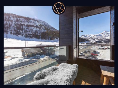 ヘムセダールにあるFyri Resort nr 14の雪に覆われた山の景色を望む大きな窓付きの客室です。