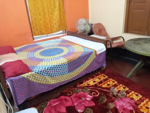 - une chambre avec un lit, une table et un tapis dans l'établissement PRATIMA GUEST HOUSE , Kolkata, à Kolkata