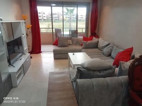 - un salon avec un canapé et une télévision dans l'établissement Appartement Prestigia Marrakech, à Marrakech