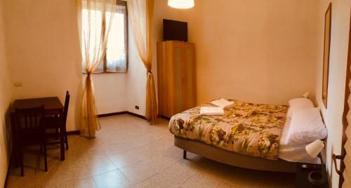 ローマにあるSan Giovanni Apartmentのベッドルーム1室(ベッド1台、デスク、窓付)