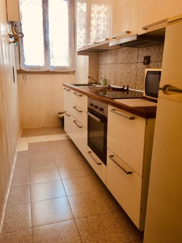 cocina con armarios blancos y fogones en San Giovanni Apartment, en Roma