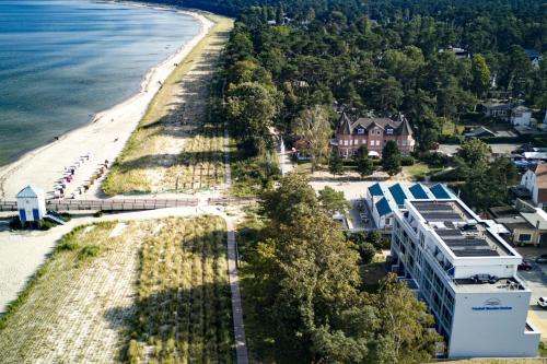 eine Luftansicht auf einen Strand und ein Haus in der Unterkunft Hotel Seebrücke in Lubmin