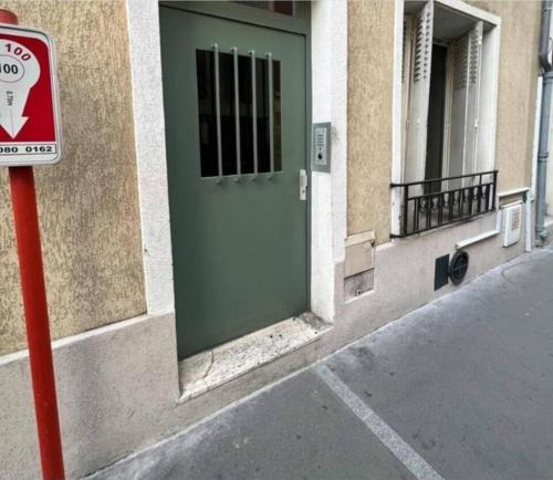 une porte verte sur le côté du bâtiment dans l'établissement Tranquillité, à Vincennes