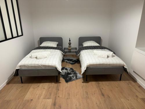 Habitación con 2 camas individuales y suelo de madera. en Appartement VIII - Haut Standing proche Luxembourg et Cattenom, en Nilvange