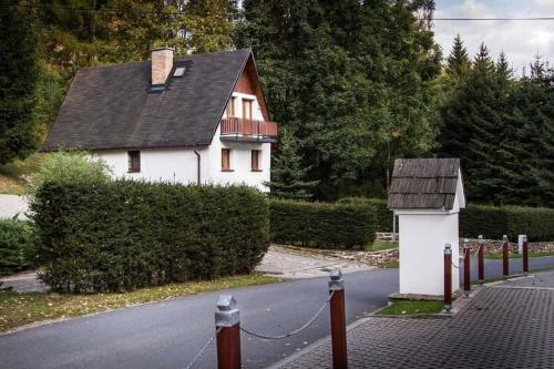 una casa blanca al lado de una carretera en Chata u Sněženky, en Šumperk