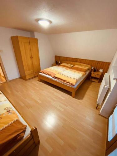 a bedroom with a bed and a wooden floor at Chata u Sněženky in Šumperk