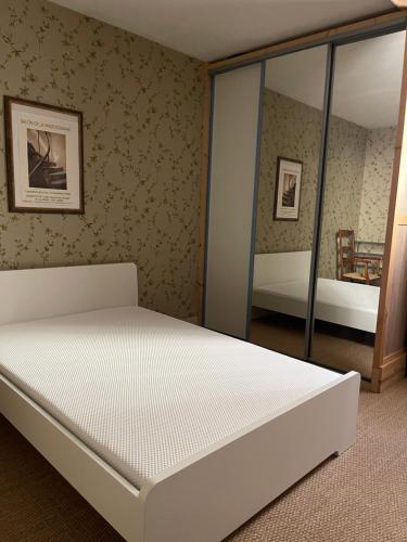 une chambre avec un lit blanc et un miroir dans l'établissement Magnifique villa 11 couchages, à Narbonne