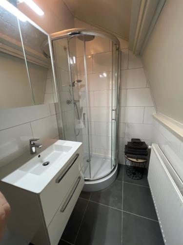 a bathroom with a shower and a sink and a tub at Appartement Warmond in Warmond