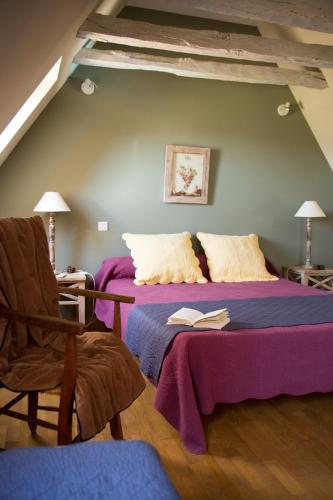 - une chambre avec un lit et un livre dans l'établissement Gîtes La Maison des Templiers, à Larche