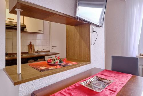 a kitchen with a table with a red table cloth at Komfort Appartement Sylt - direkt am Strand - in Westerland (Sylt)