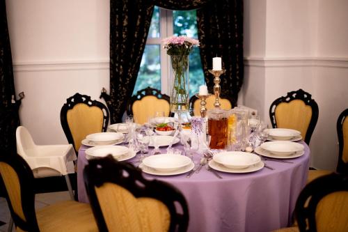 una mesa púrpura con platos y vasos. en Kasztanowy Dwór, en Cieszyn