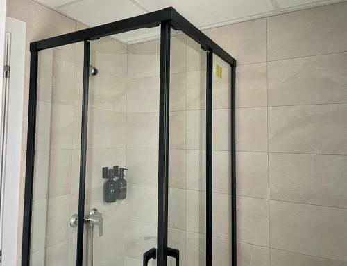 a shower with a glass door in a bathroom at Casa Carivid en el centro y con parking gratis in Sanlúcar de Barrameda