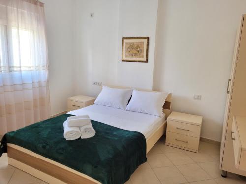 a bedroom with a bed with two towels on it at Parid Appartments in Sarandë