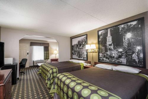 a hotel room with two beds and a television at Super 8 by Wyndham Knoxville West/Farragut in Knoxville