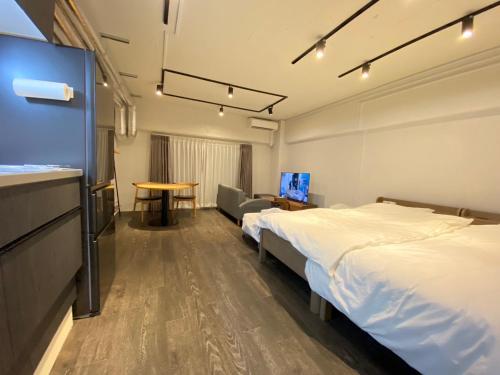 um quarto de hotel com duas camas e uma mesa em NIYS apartments 37 type em Tóquio