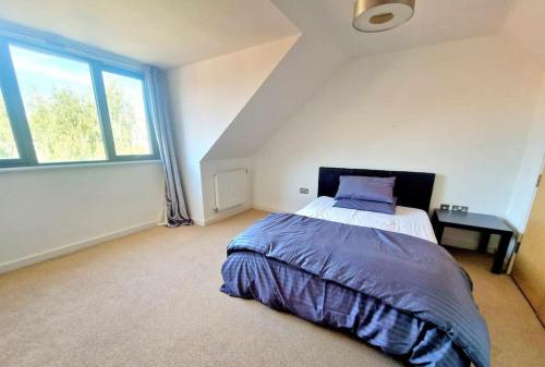 a bedroom with a bed and a large window at Explore London: 2 Bedroom House in Wood Green in London