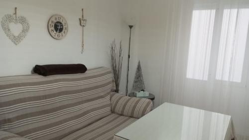 een witte woonkamer met een bank en een raam bij Acogedor apartamento JV36 in Córdoba