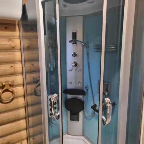 a bathroom with a shower with a toilet in it at Agroturystyka dom z bali całoroczny in Turbia
