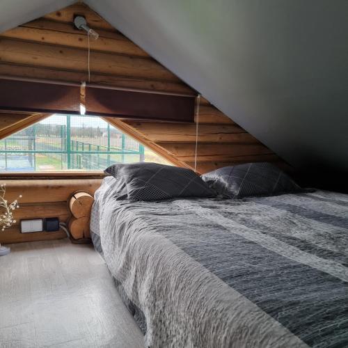 a bed in a room with a large window at Agroturystyka dom z bali całoroczny in Turbia