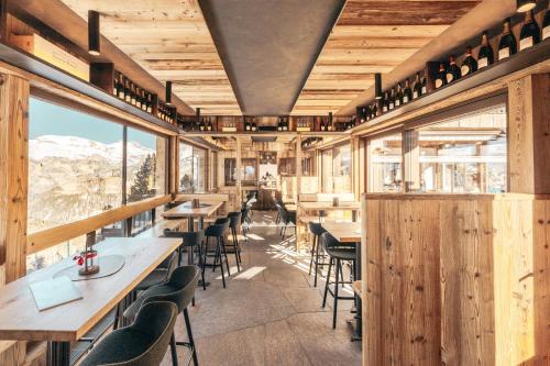 ein Restaurant mit Holzwänden, Tischen und Stühlen in der Unterkunft Hotel Piz Seteur in Wolkenstein in Gröden