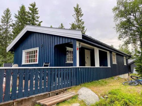 una casita azul con porche en Hytte til leie på Budor, en Nordset